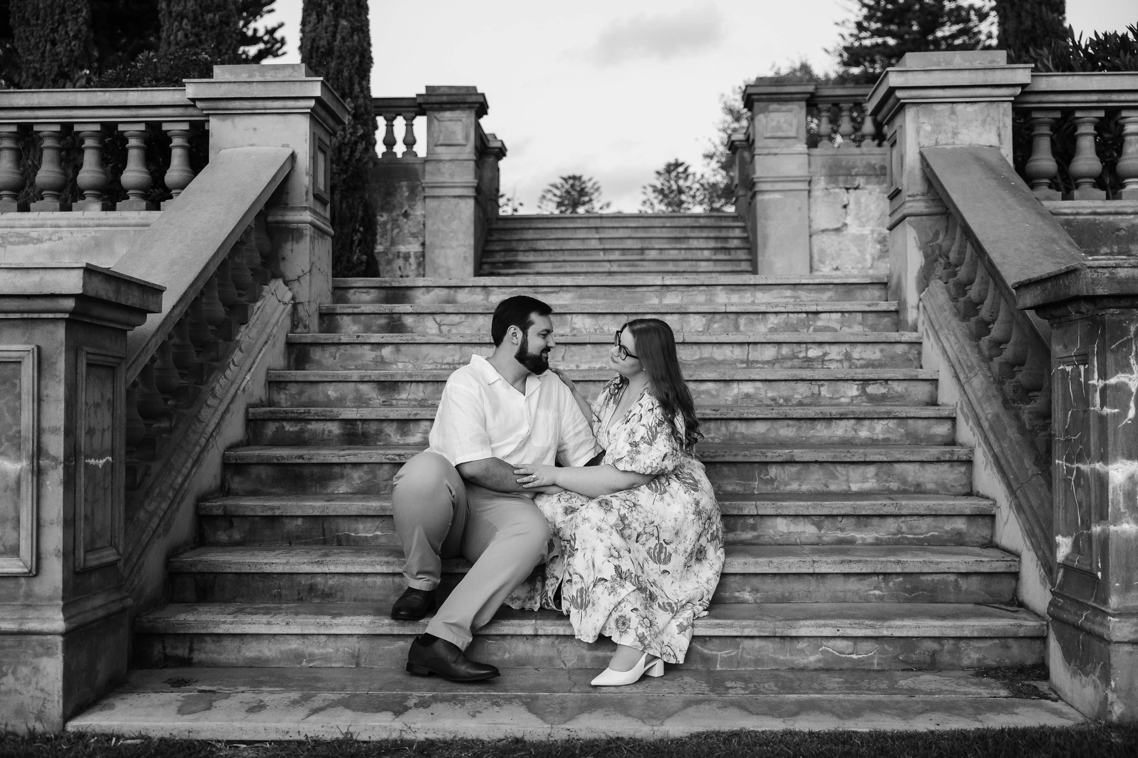 Samantha and Joel holding hands on a balustrade at sunset